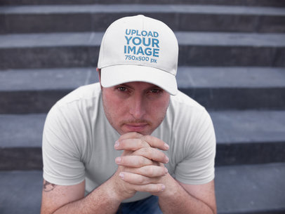 White Guy Sitting Down on Concrete Stairs While Wearing a Dad Hat Mockup