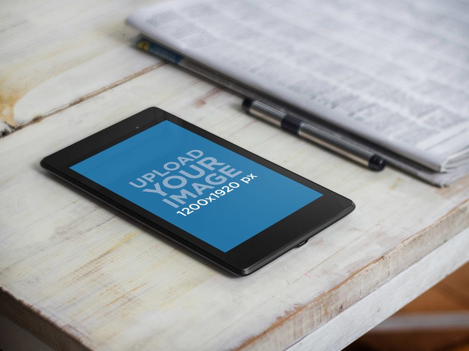 Mockup of a Nexus 7 in Portrait Mode Placed Next to a Newspaper