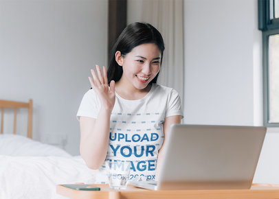 Basic T-Shirt Mockup of a Woman on a Video Call at Home 