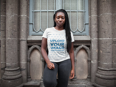 Mockup of a Woman with Braids Wearing a T-Shirt Mockup While Outside a Church