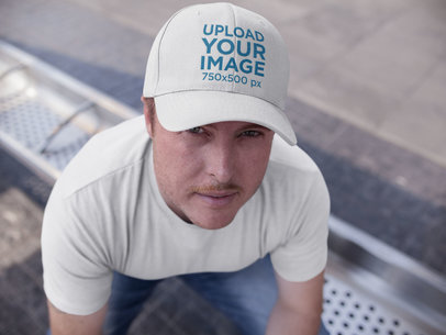 Middle Aged White Guy Wearing a Dad Hat While Sitting Down at a Bus Station