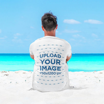 Back View T-Shirt Mockup Featuring a Man Sitting at the Beach