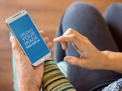 Galaxy 4 Mockup Featuring a Woman Sitting on a Striped Couch
