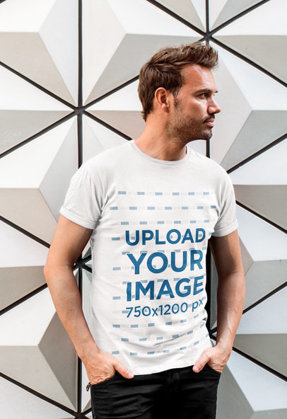 T-Shirt Mockup of a Bearded Man Posing in Front of a Patterned Wall
