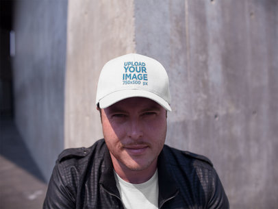 Happy White Man Looking to the Camera While Wearing a Hat Template Against a Concrete Wall a15886