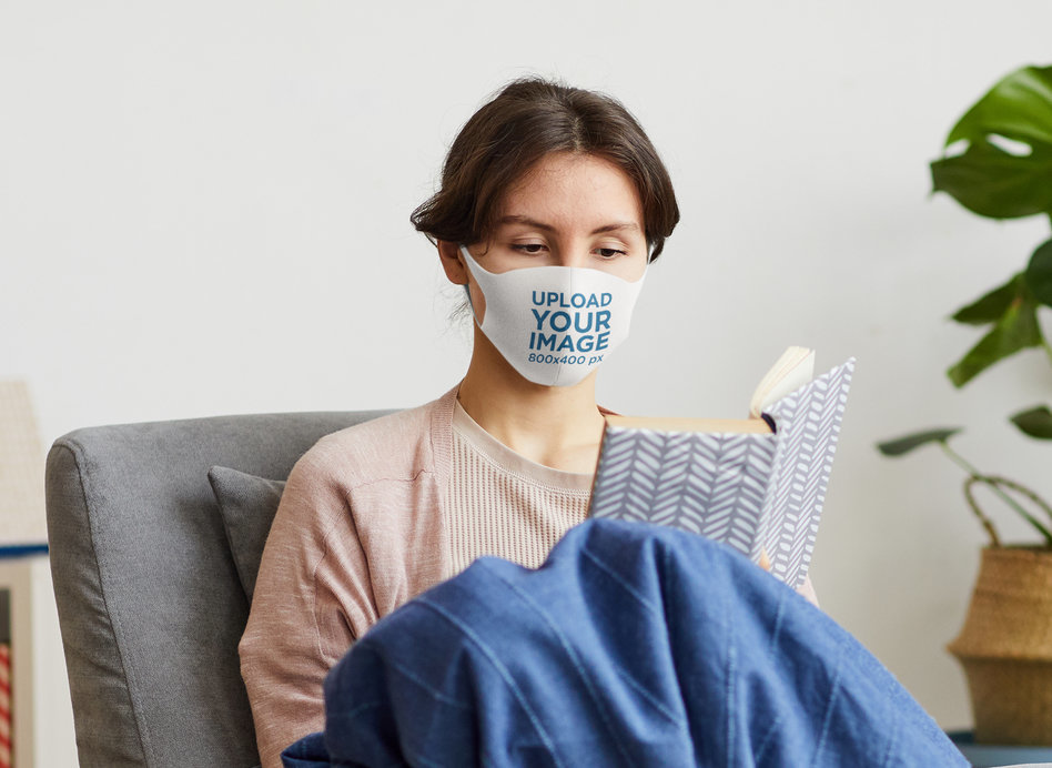 Mockup of a Woman Reading in her Living Room with a Face Mask