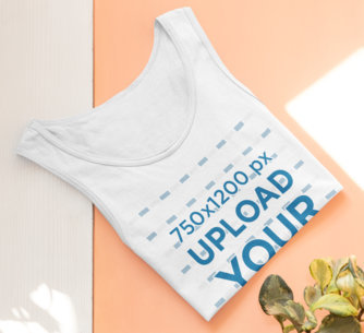Mockup of a Folded Tank Top Lying by Some Plants