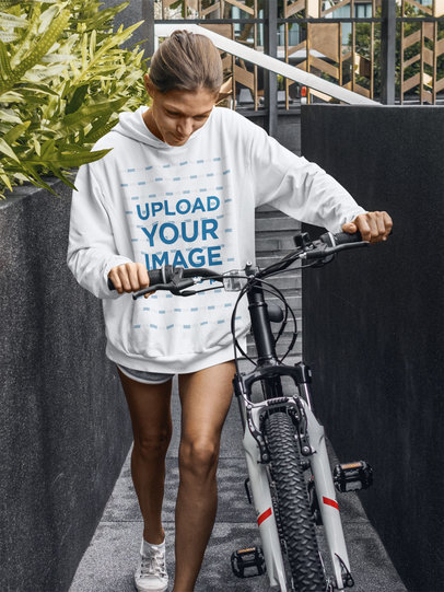 Hoodie Mockup Featuring a Serious Woman Walking With Her Bike m4289-r-el2
