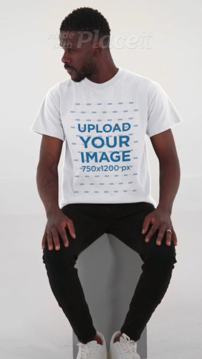 T-Shirt Video Featuring a Serious Man Sitting on a Stool