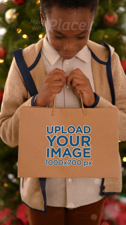 Video of a Cute Smiling Boy Carrying a Paper Gift Bag for Christmas