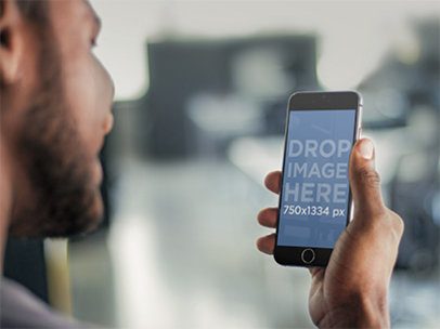 Mockup of a Young Man Using a Black iPhone 6 Smartphone