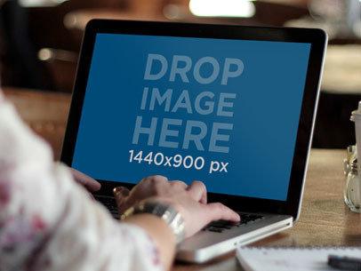 Mockup of a Woman Typing on a MacBook Pro