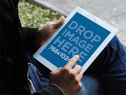 Mockup of a Man Using a White iPad in park