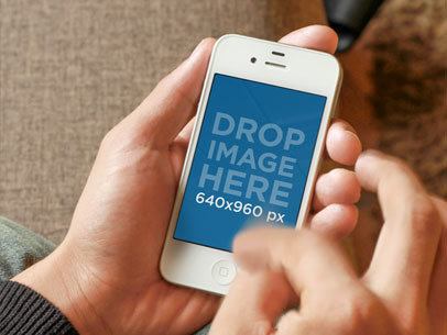 Mockup of a Man Scrolling Down his White iPhone 4