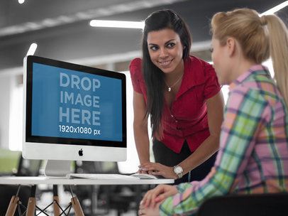 Two Young Businesswoman Chatting in Front of an iMac Mockup