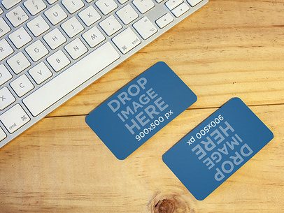 Mockup of Two Business Cards Lying On Top of a Desk at an Office