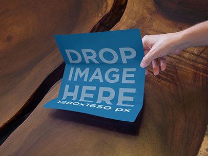 Mockup of a Person Grabbing a Brochure From a Wooden Coffee Table a6331