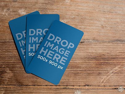 Mockup Featuring Three Business Cards Lying on Top of a Wooden Table
