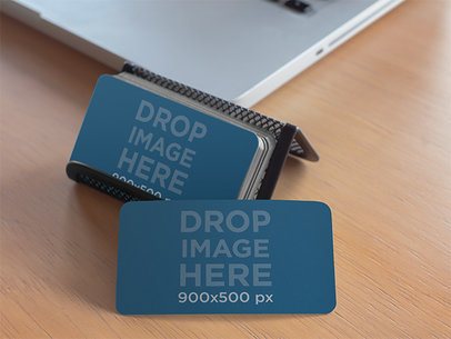Business Card Holder Sitting Next to a Macbook Pro Mockup