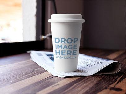 Label Mockup Featuring a Coffee Cup Standing on Top of a Newspaper 