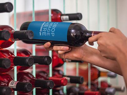 Label Mockup Featuring a Man Taking a Wine Bottle From a Wine Cellar