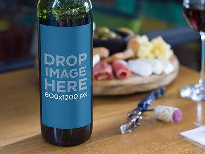 Label Mockup of a Wine Bottle Standing on Top of a Table at a Restaurant