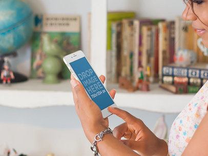 iPhone Mockup of a Woman Using an iPhone 6 in a Living Room 