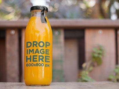 Label Mockup of a Juice Bottle Sitting on Top of a Table at a Patio