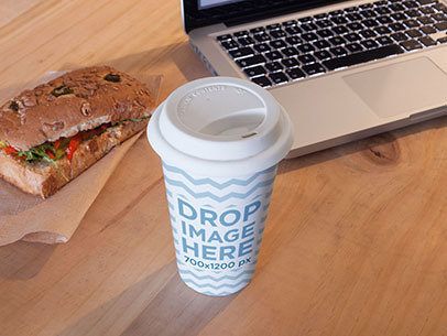 Coffee Cup Mockup Sitting Next to a Sandwich and a Macbook Pro