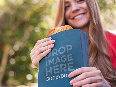 Paper Bag Mockup Featuring a Young Woman Eating a Sandwich