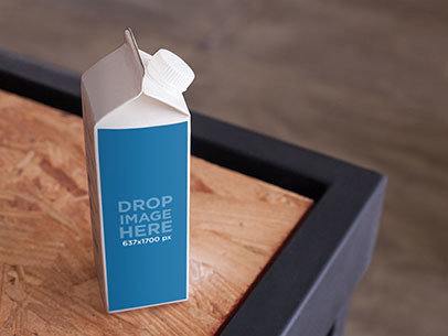 Packaging Mockup of a Milk Carton Over a Wooden Table 