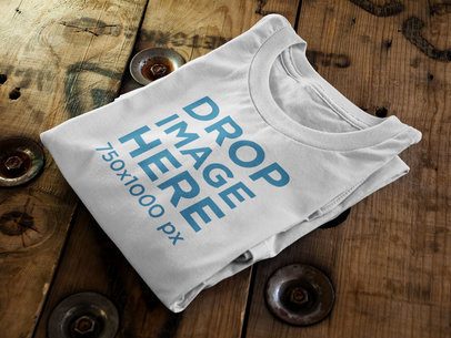 Folded T-Shirt Mockup Sitting On Top of a Wooden Table