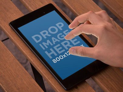 Mockup of Someone Using a Nexus 7 on a Wooden Surface