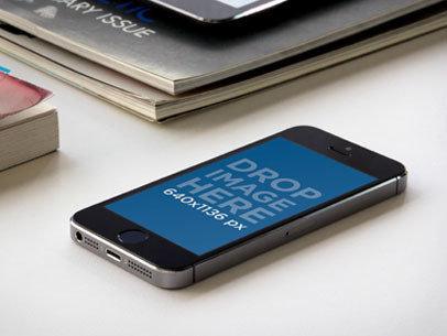 Mockup of an iPhone 5 Placed Next to Some Books