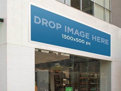 Horizontal Banner Mockup Hanging From a Wall Outside a Store