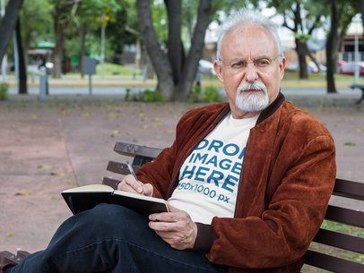 T-Shirt Mockup of an Elder Man at the Park Reading