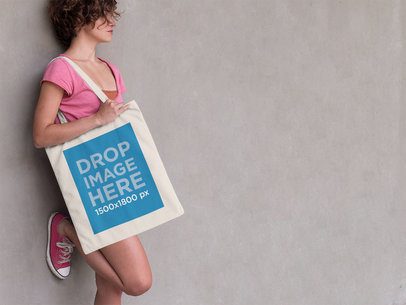 Woman Leaning Against a Wall With a Tote Bag Mockup