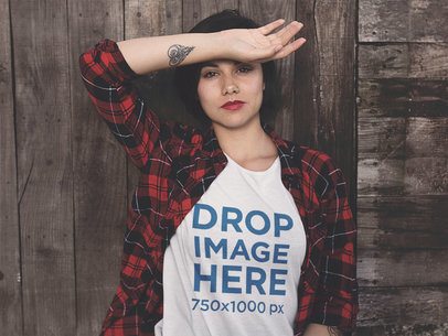 T-Shirt Mockup of a Grungy Woman Leaning on a Wooden Wall