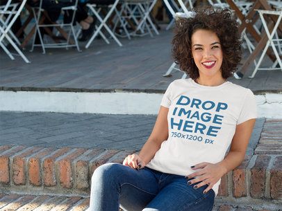 Tee Mockup of a Woman Smiling While Sitting Casually  