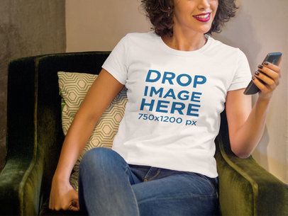 T-Shirt Mockup of a Smiling Woman Sitting With a Phone 