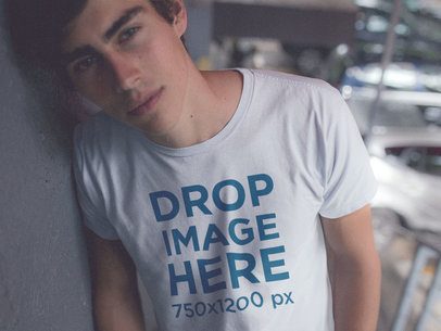 Mockup of a Trendy Guy Wearing a Tee Leaning Against a Wall