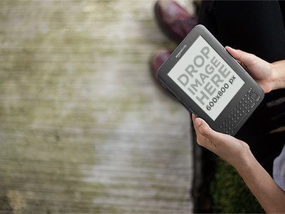 Young Man Holding a Kindle Outside Mockup