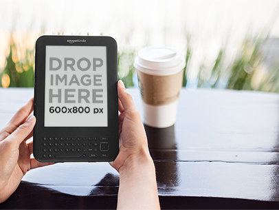 Kindle Held with Both Hands at a Coffee Shop Mockup