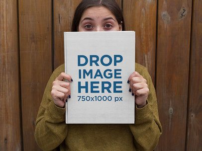 Woman Holding a Book Cover Mockup With Her Eyes Wide Open a12032