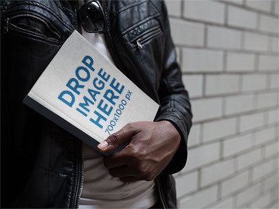 Paperback Book Cover Mockup Held by a Young Man