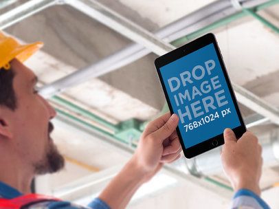 Mockup of a Man Holding High an iPad in Portrait Mode 12430