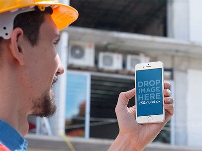 iPhone Mockup in Portrait Mode of a Man Standing Outside a Construction Site