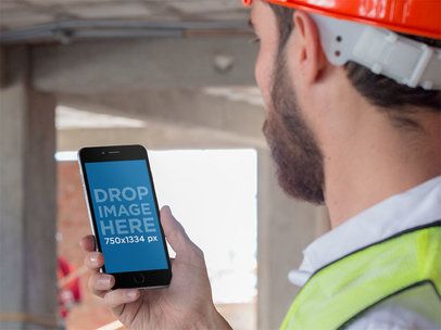 Mockup of a Worker Looking at His iPhone in Portrait Mode