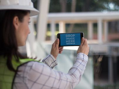 Female Architect Holding a Black iPhone Plus in Landscape View Mockup
