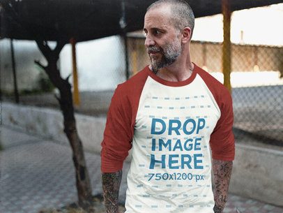 Man Wearing a Simple Raglan T-Shirt Mockup at a Downtown Alley